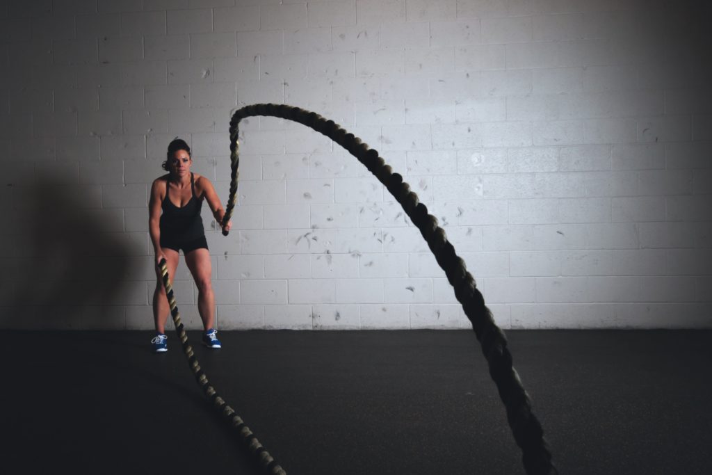 Technical Penguins White Paper on WordPress speed optimization: A background image shows a woman in athletic wear using ropes as part of a Crossfit workout.