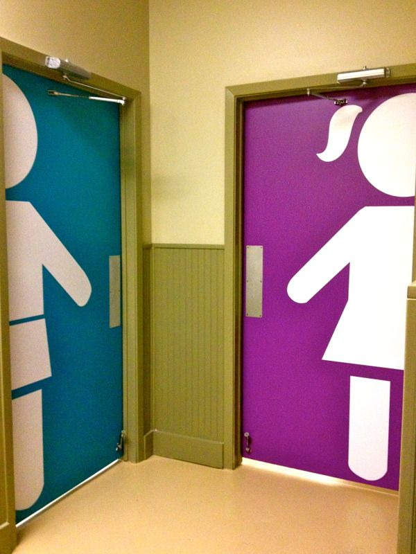 A blue pictogram of a person wearing parts and an arrow pointing one direction is seen next to a pink pictogram of a person in a skirt.